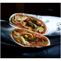 Een extra grote wrap, royaal gevuld met çiğköfte, frisse groenten, citroen, granaatappelsaus en optioneel onze huisgemaakte pittige saus