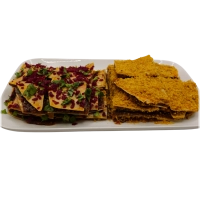 Twee lagen lavaş met daartussen een royale laag çiğköfte, in stukken gesneden en afgewerkt met stukjes peterselie en rode-koolturşu. Geschikt voor 4 personen