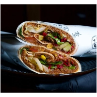 Een vers bereide lavaşwrap, royaal gevuld met çiğköfte, frisse groenten, citroen, granaatappelsaus en optioneel onze huisgemaakte pittige saus